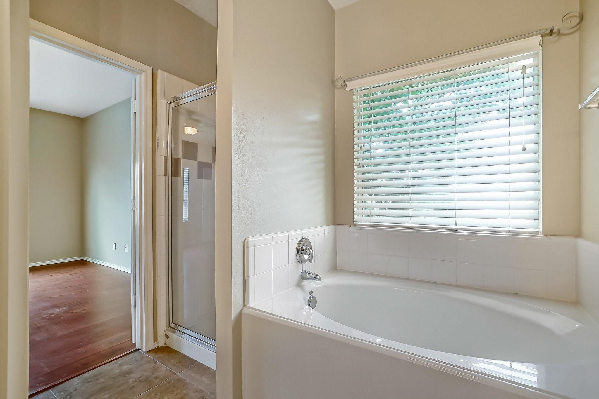 3410 Azalea Sands Drive Spring, TX 77386 - Photo 11 of 40 a bathroom with a bathtub and a shower