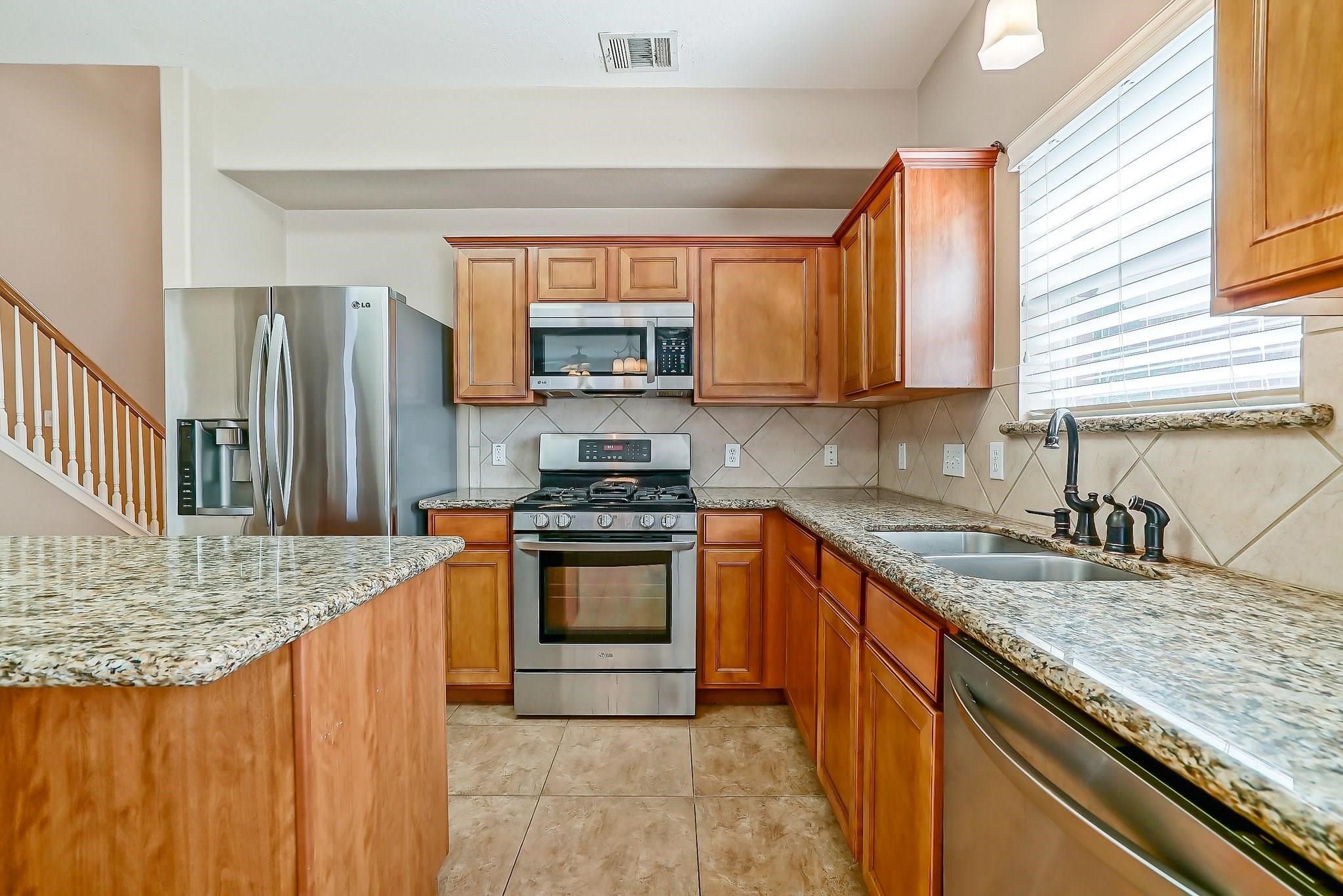 3410 Azalea Sands Drive Spring, TX 77386 - Photo 21 of 40 a kitchen with granite countertop a sink stove and refrigerator