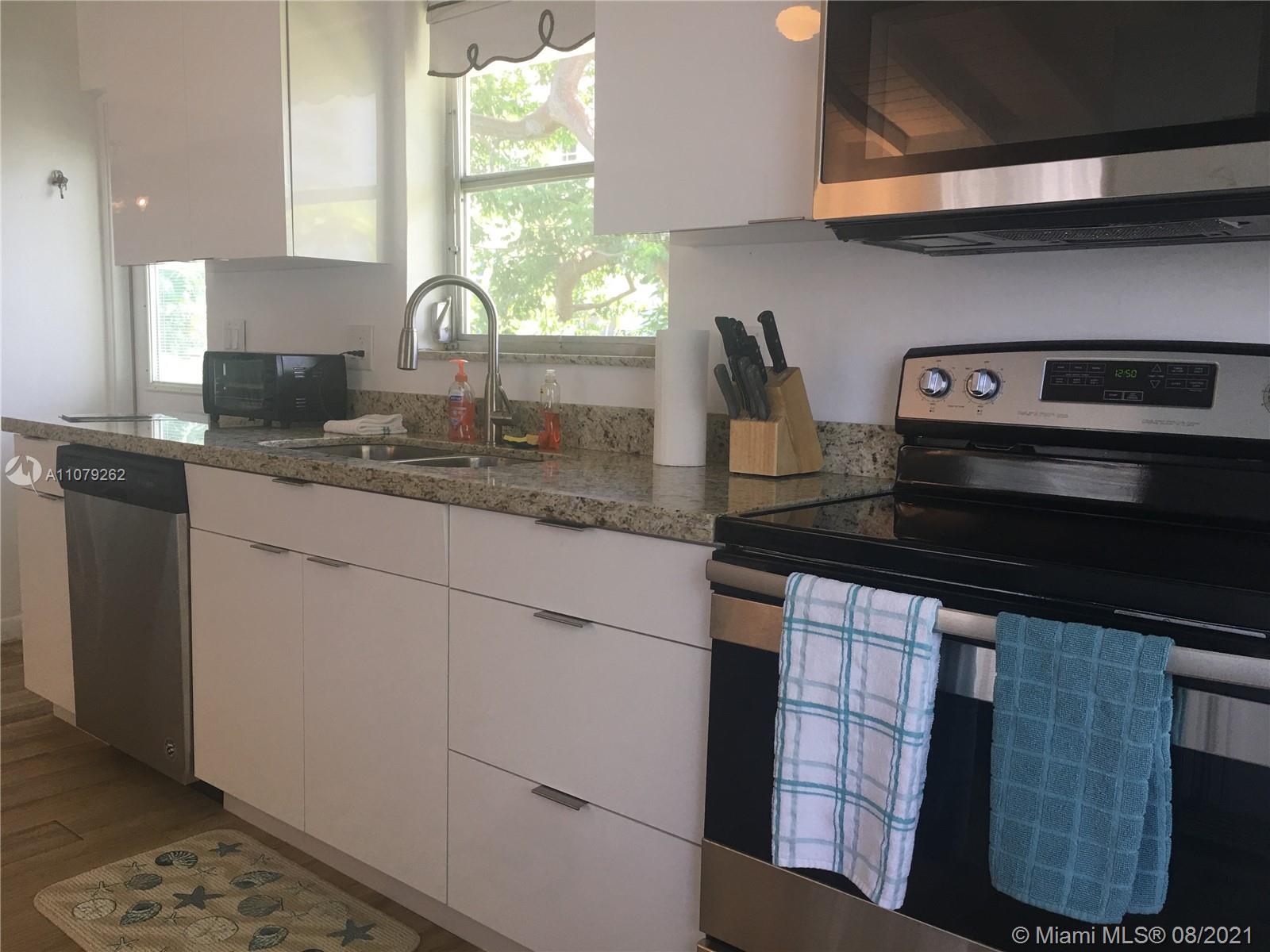 524 North Riverside Drive Pompano Beach, FL 33062 - Photo 15 of 35 a kitchen with stainless steel appliances granite countertop a sink stove and cabinets