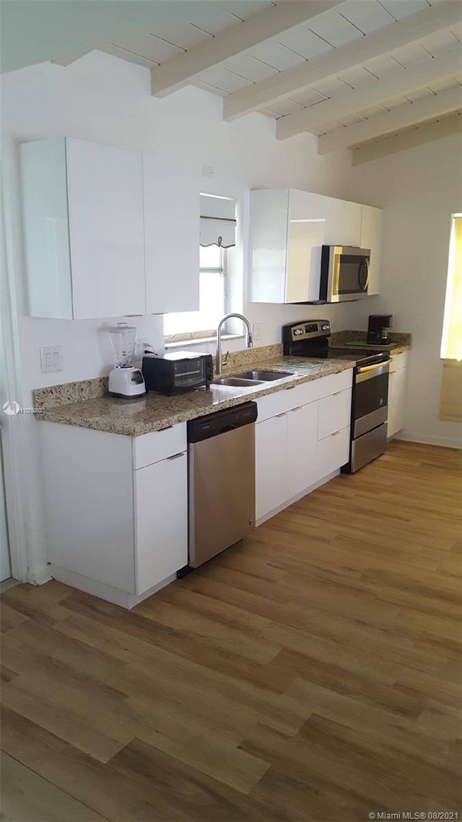 524 North Riverside Drive Pompano Beach, FL 33062 - Photo 16 of 35 a kitchen with stainless steel appliances granite countertop a sink and stove top oven