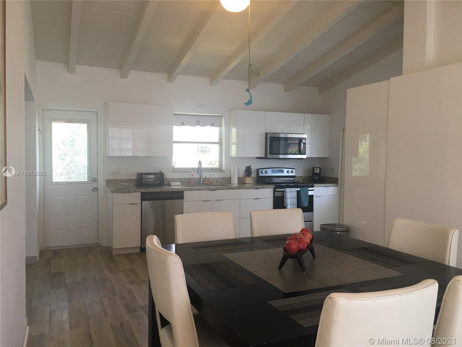 524 North Riverside Drive Pompano Beach, FL 33062 - Photo 19 of 35 a kitchen with granite countertop a refrigerator a stove a sink a dining table and chairs
