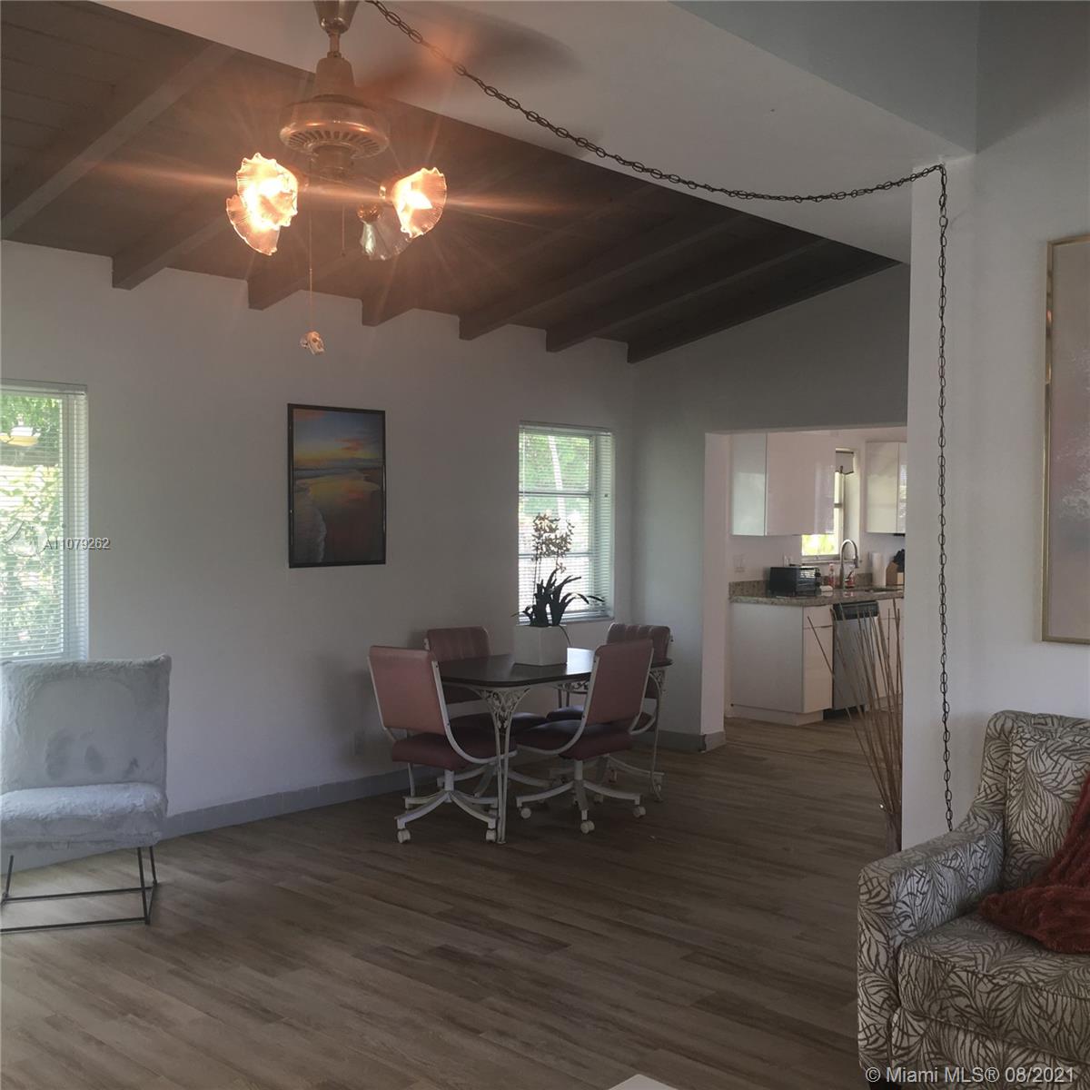 524 North Riverside Drive Pompano Beach, FL 33062 - Photo 9 of 35 a dining room with wooden floor a chandelier a wooden table and chairs