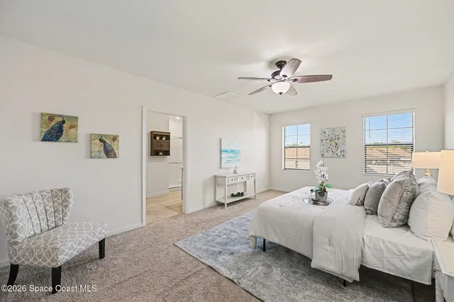 a bedroom with a bed couches and window