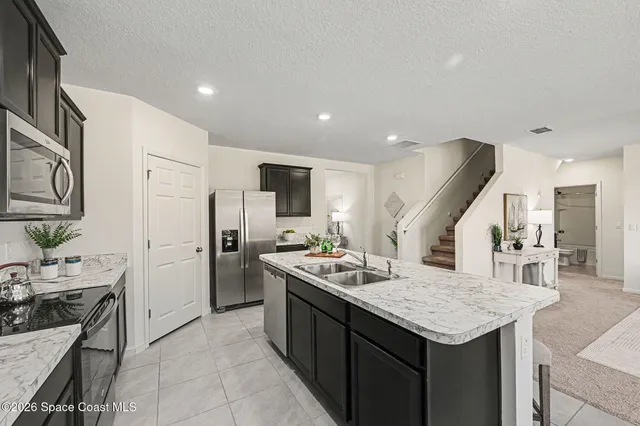a kitchen that has a lot of cabinets a sink and appliances