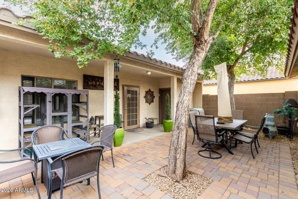 a view of a patio with table and chairs and potted plants with large tree