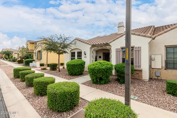 a view of a white house with a big yard and potted plants