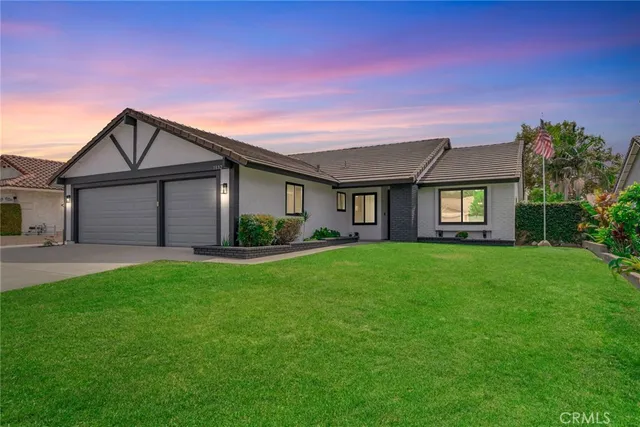 a front view of a house with a garden and yard