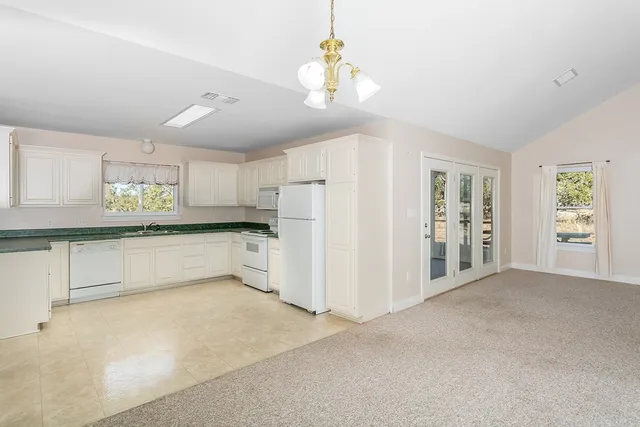 a large white kitchen with cabinets and a refrigerator