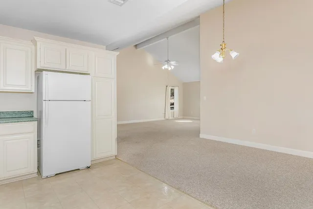 a view of a kitchen with a refrigerator and cabinets