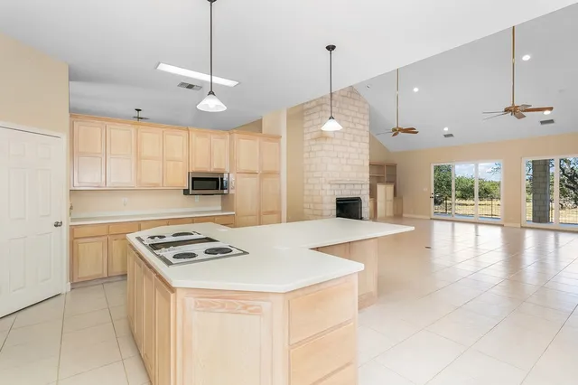 a kitchen with granite countertop a stove a sink a refrigerator and a stove