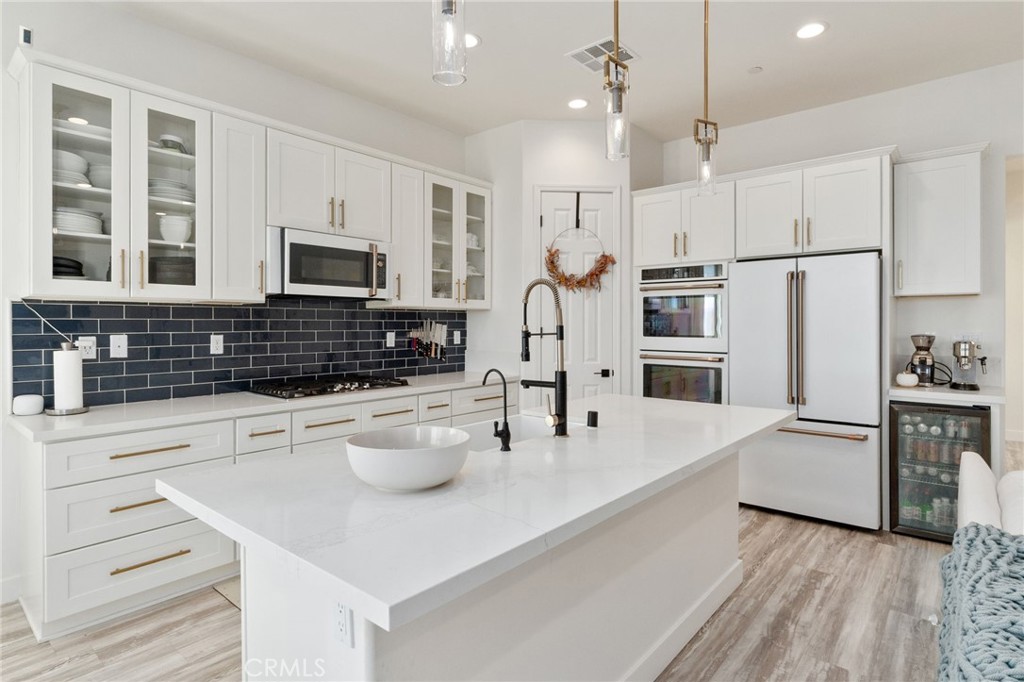 2308 Nova Way Corona, CA 92883 - Photo 10 of 32 a kitchen with white cabinets and stainless steel appliances