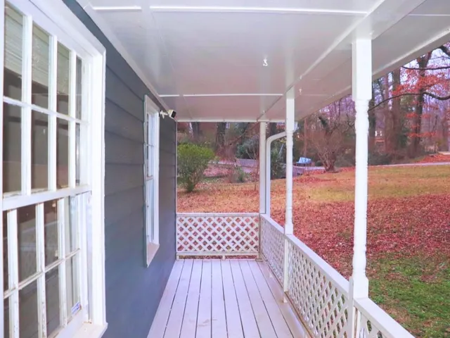 an empty room with wooden floor fireplace and windows