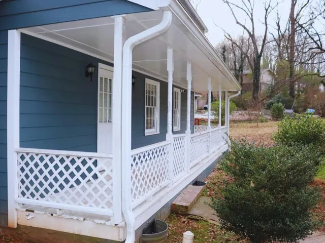 a view of a hallway with wooden floor and a bathroom
