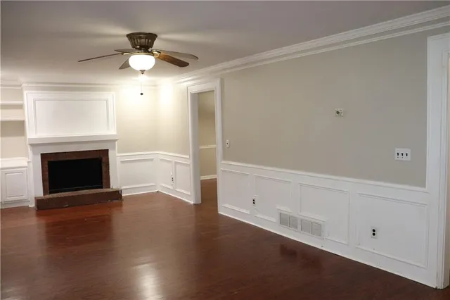 an empty room with wooden floor chandelier fan and closet area