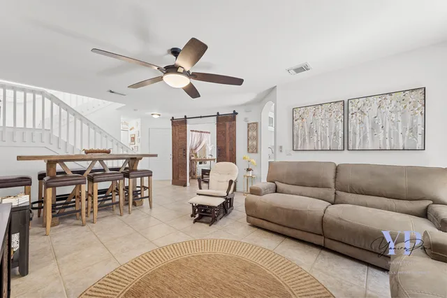 a living room with furniture kitchen view and a large window