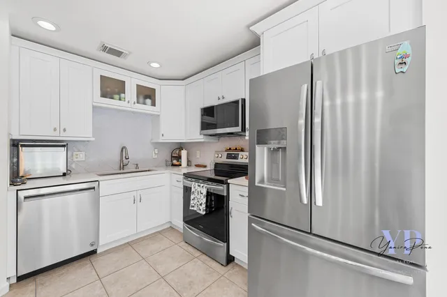 a kitchen with stainless steel appliances granite countertop a refrigerator sink and stove