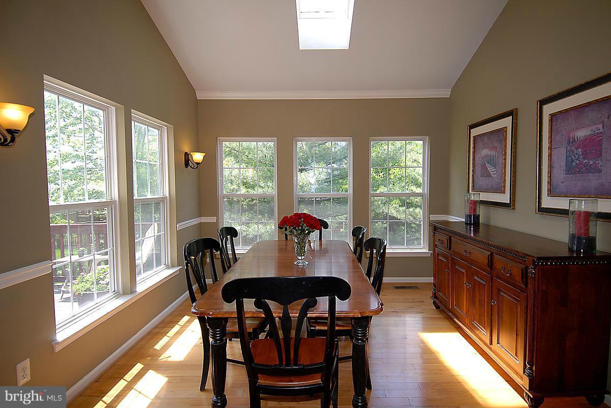 43233 Stillforest Terrace Ashburn, VA 20147 - Photo 12 of 30 a view of a dining room with furniture large windows and wooden floor