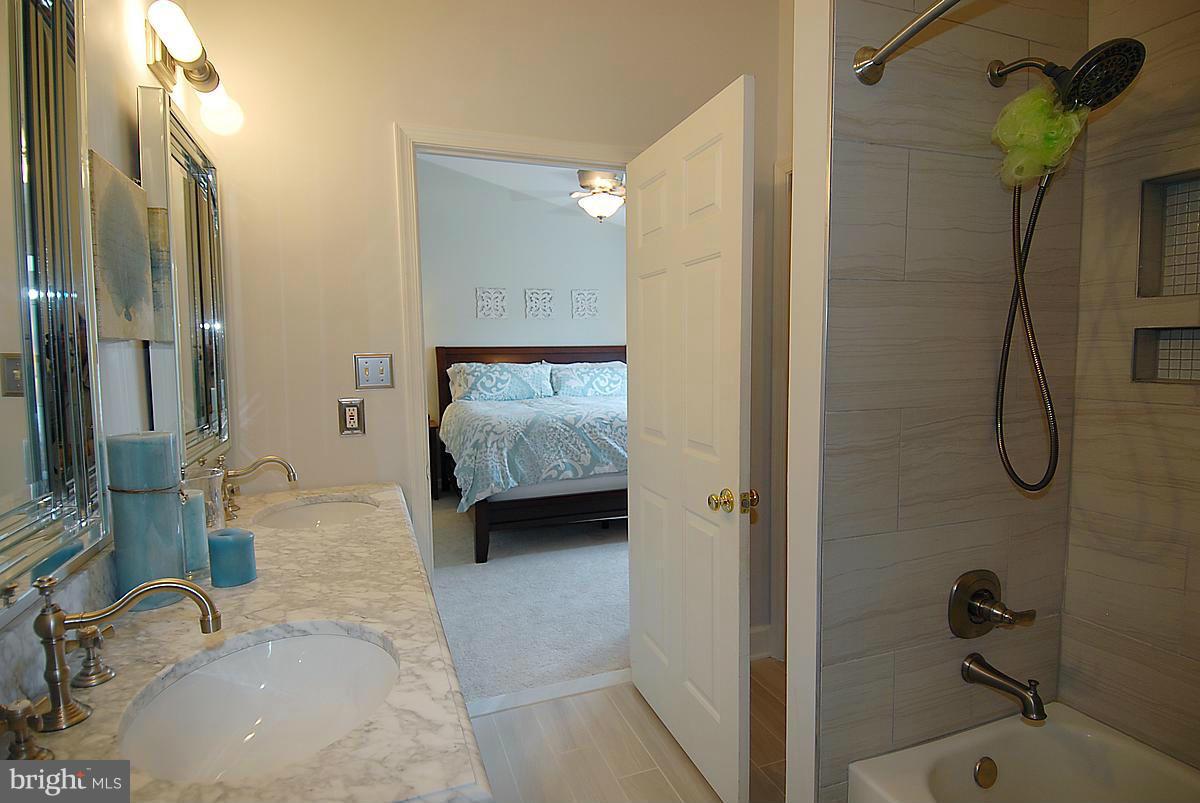 43233 Stillforest Terrace Ashburn, VA 20147 - Photo 20 of 30 a en suite bathroom with a granite countertop sink and a mirror