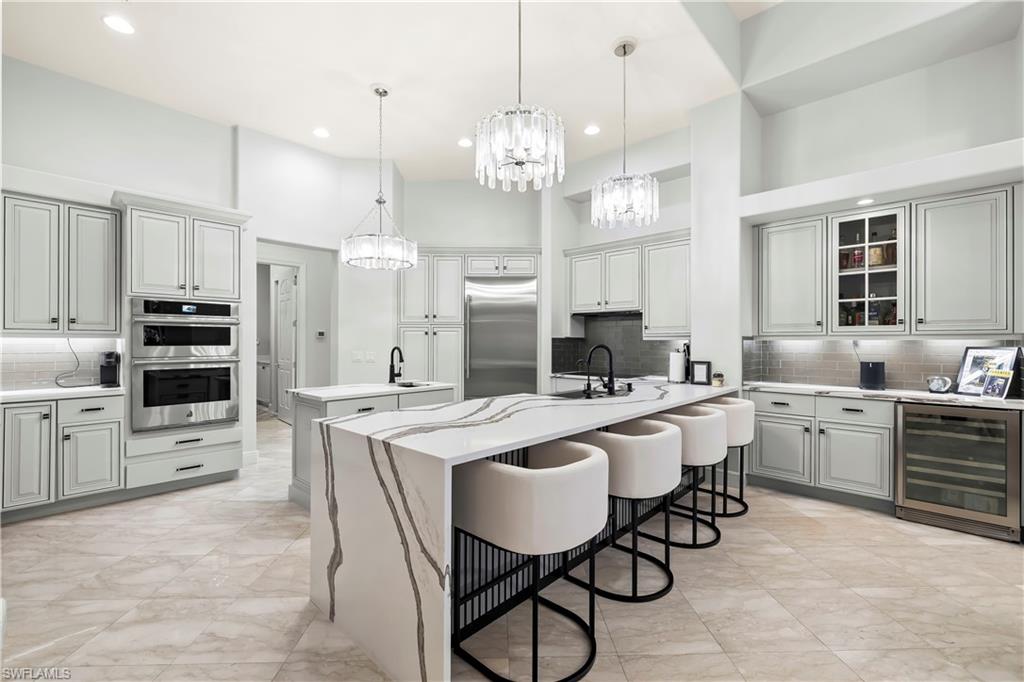 480 Terracina Way Naples, FL 34119 - Photo 2 of 40 Kitchen with wine cooler, backsplash, decorative light fixtures, stainless steel appliances, and recessed lighting