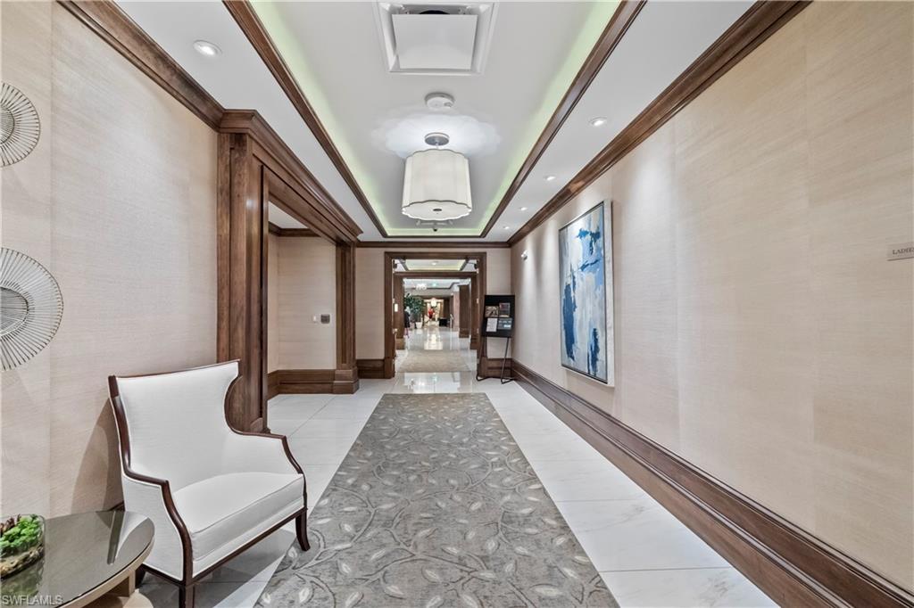 480 Terracina Way Naples, FL 34119 - Photo 35 of 40 Corridor with wallpapered walls, crown molding, light tile patterned floors, a tray ceiling, and recessed lighting