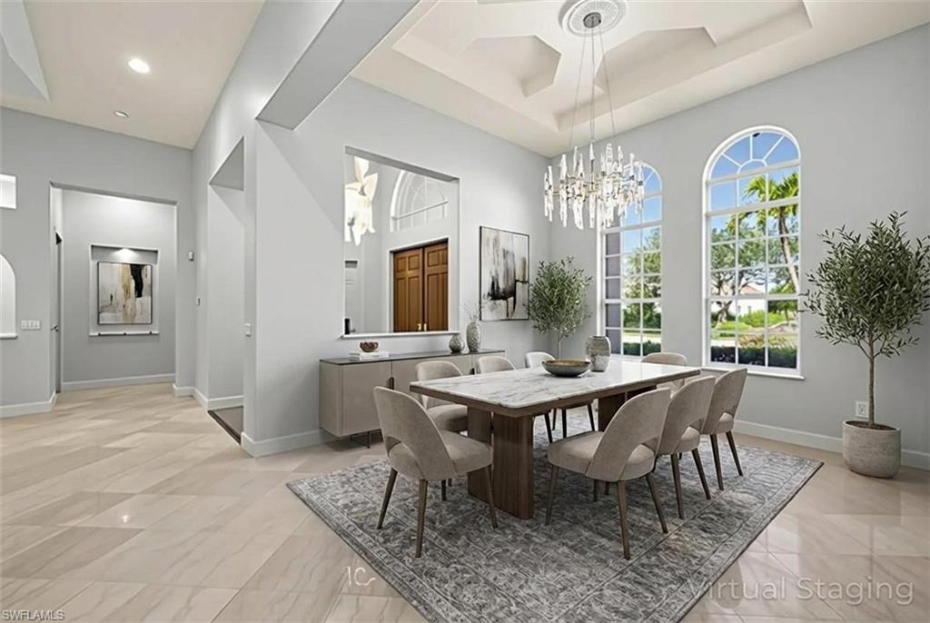 480 Terracina Way Naples, FL 34119 - Photo 5 of 40 Dining space featuring a chandelier, a tray ceiling, a towering ceiling, and recessed lighting