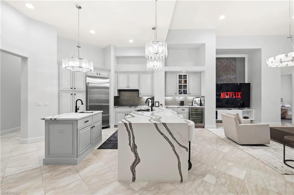 480 Terracina Way Naples, FL 34119 - Photo 6 of 40 Kitchen featuring a chandelier, pendant lighting, wine cooler, built in fridge, and recessed lighting