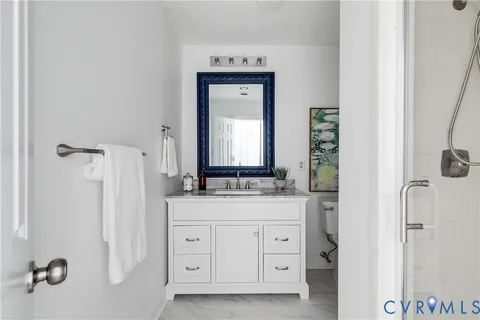 a bathroom with a granite countertop sink a mirror and a shower