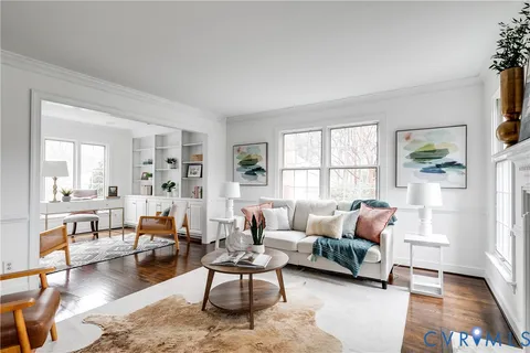 a living room with furniture a rug a lamp and a window