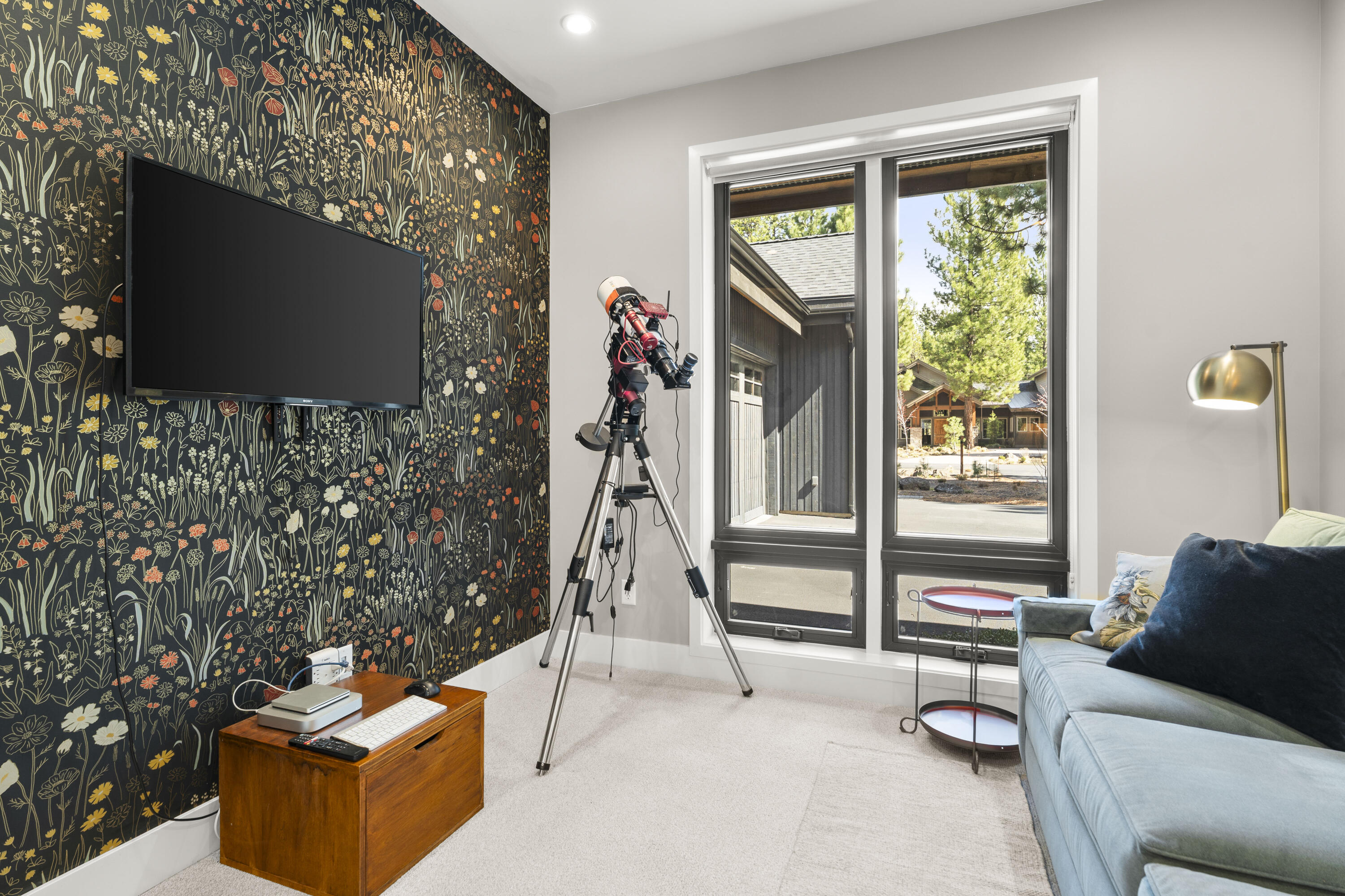 56670 Sunstone Loop, Unit LOT 141 Bend, OR 97707 - Photo 8 of 62 This cozy den stands out with its dramatic wallpapered accent wall, soft carpet underfoot, and natural light from the large window. An ideal flex space for lounging, TV, hobbies, or a private sitting room.