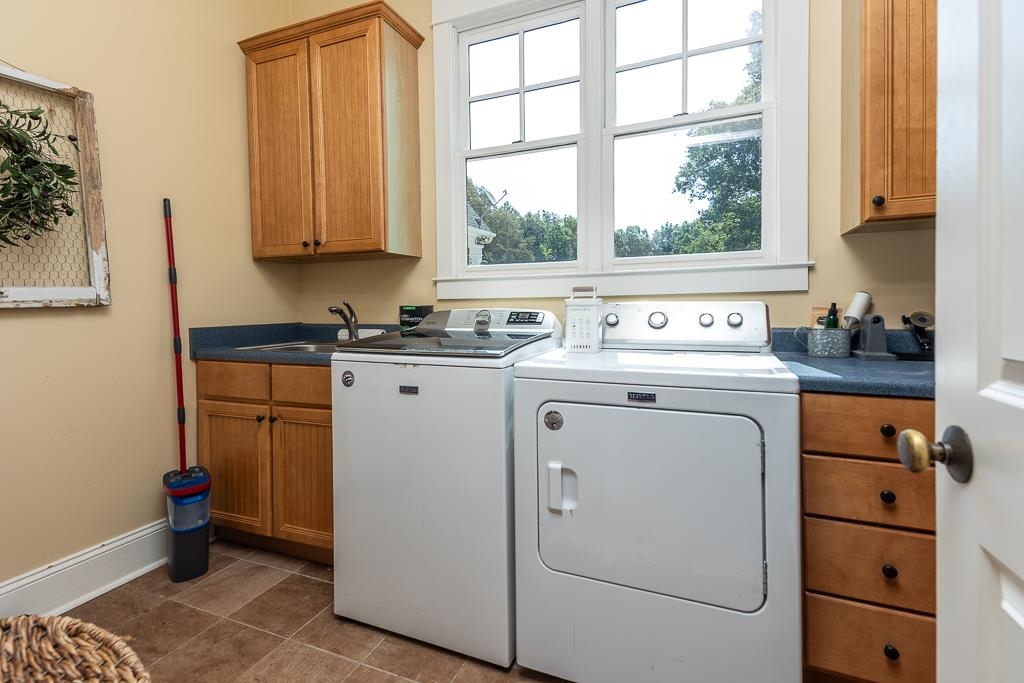 1915 Teague Store Road Somerville, TN 38068 - Photo 35 of 38 Laundry area featuring a large window, extensive cabinetry, a built-in sink, and tile flooring
