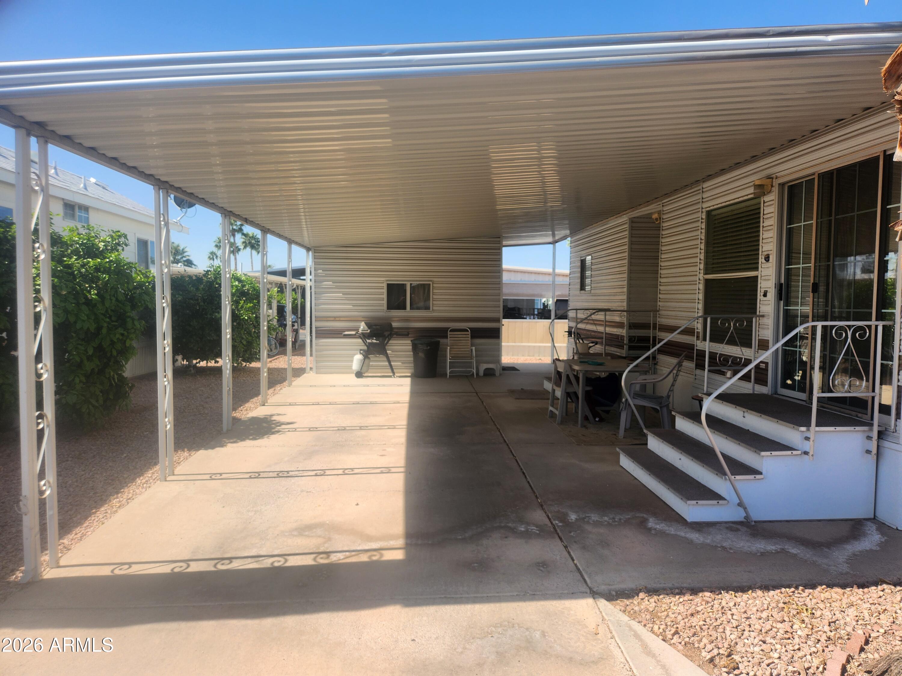 111 South Greenfield Road, Unit 211 Mesa, AZ 85206 - Photo 5 of 6 a view of a patio with table and chairs with wooden floor and fence