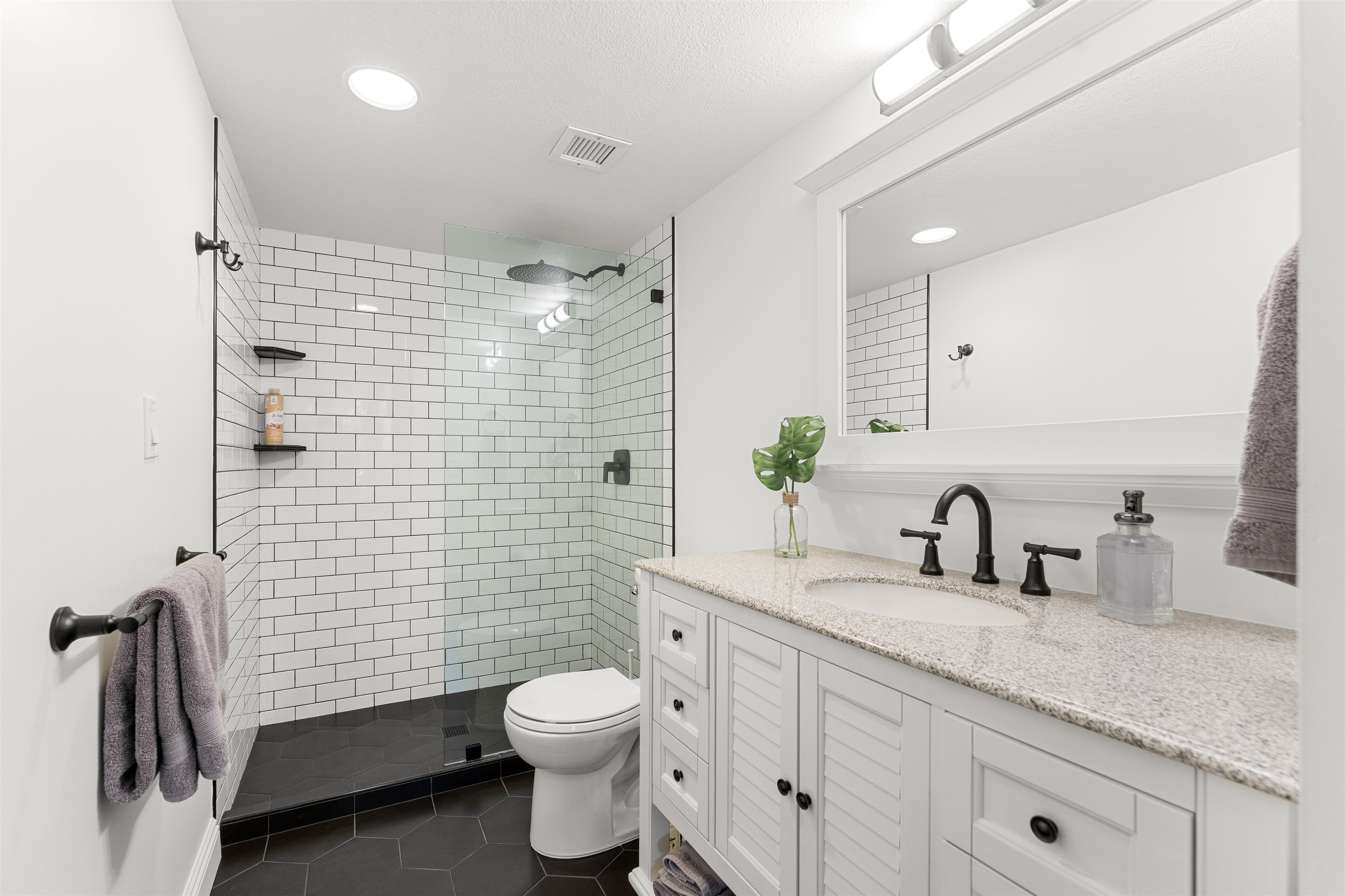 2575 South Kihei Road, Unit T110 Kihei, HI 96753 - Photo 2 of 24 a bathroom with a granite countertop toilet sink and mirror