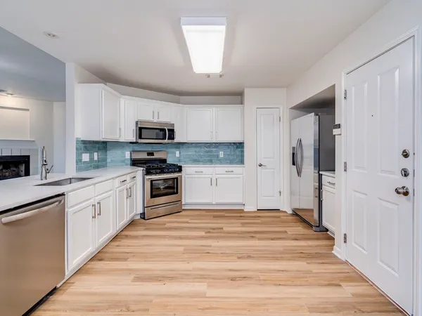 a kitchen with granite countertop a refrigerator and a stove top oven