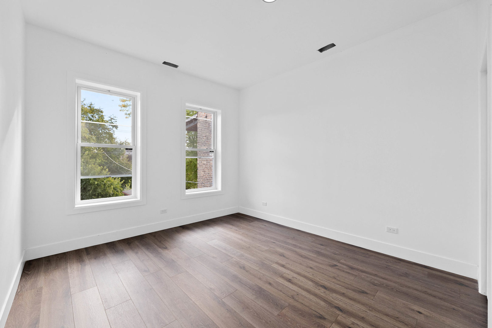 1421 East 69th Place Chicago, IL 60637 - Photo 7 of 14 an empty room with wooden floor and windows