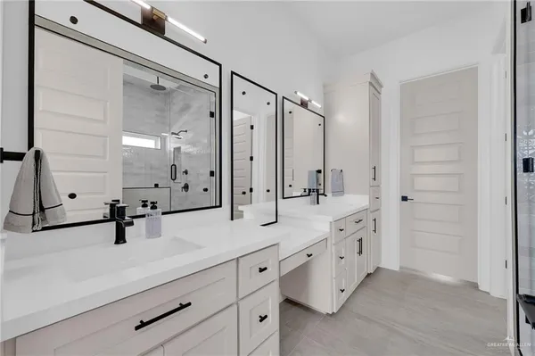 a bathroom with a double vanity sink mirror and shower