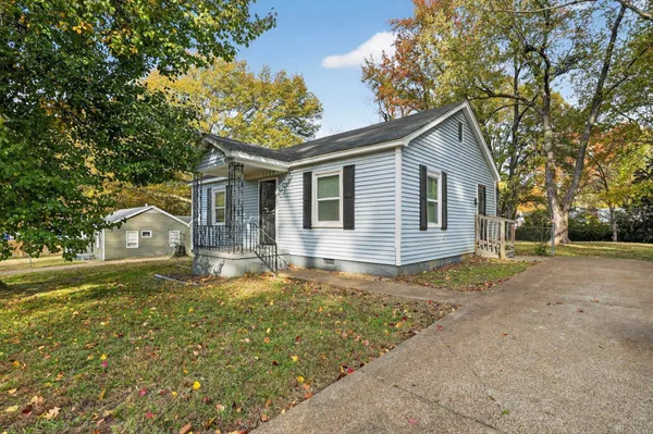 a front view of house with yard and trees