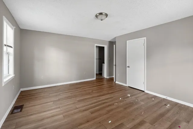 a view of an empty room with wooden floor