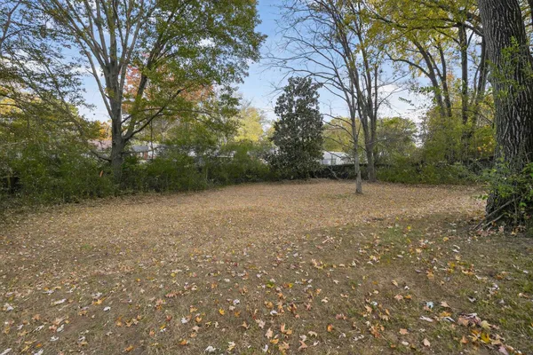 a view of a house with a big yard and large trees