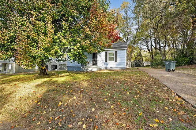 a front view of a house with a yard and trees