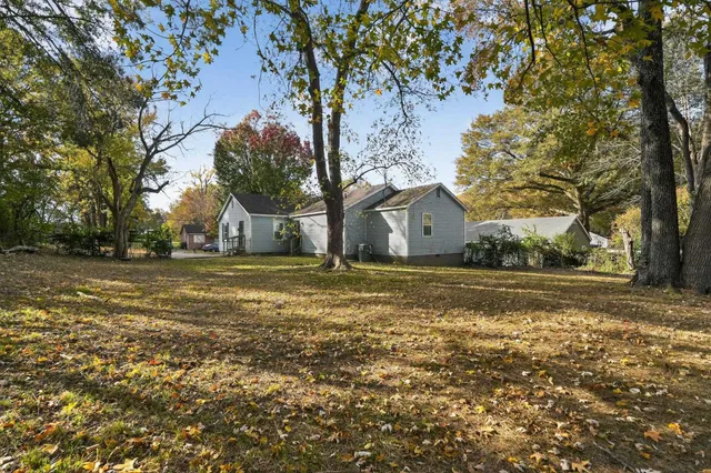 a backyard of a house with table and chairs