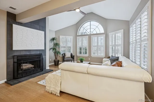 a living room with furniture a fireplace and a large window