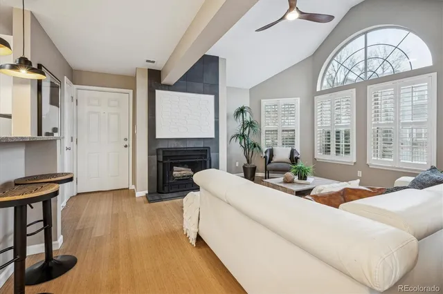 a living room with fireplace furniture and a large window