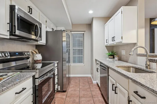 a kitchen with stainless steel appliances granite countertop a sink stove and microwave