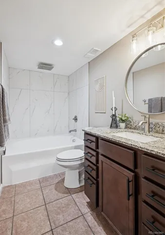 a bathroom with a granite countertop sink a toilet and bathtub