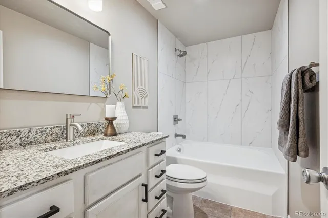a bathroom with a granite countertop sink toilet and shower