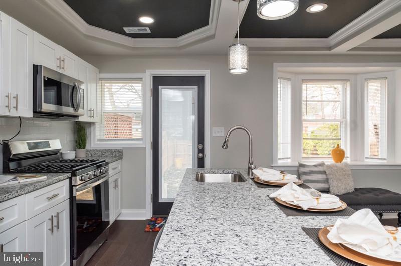 1426 East Cold Spring Lane Baltimore, MD 21239 - Photo 8 of 27 a kitchen with stainless steel appliances granite countertop a stove a sink and a microwave