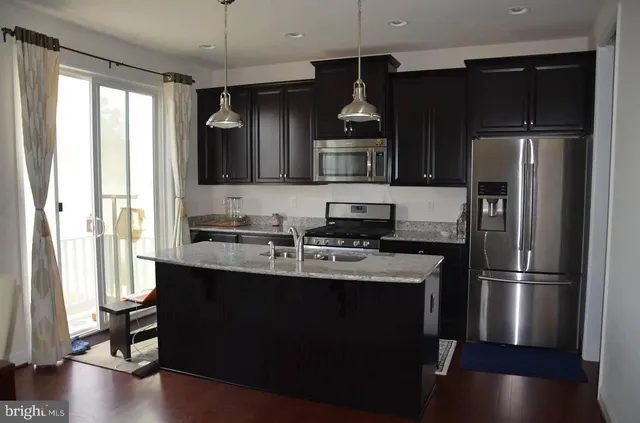 a kitchen with stainless steel appliances a sink stove and refrigerator