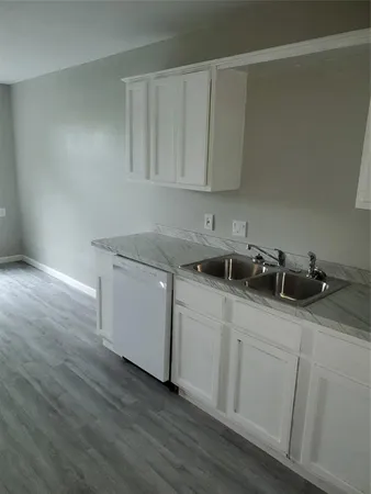 a kitchen with a sink cabinets and wooden floor