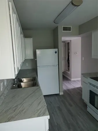 a kitchen with a refrigerator and a stove