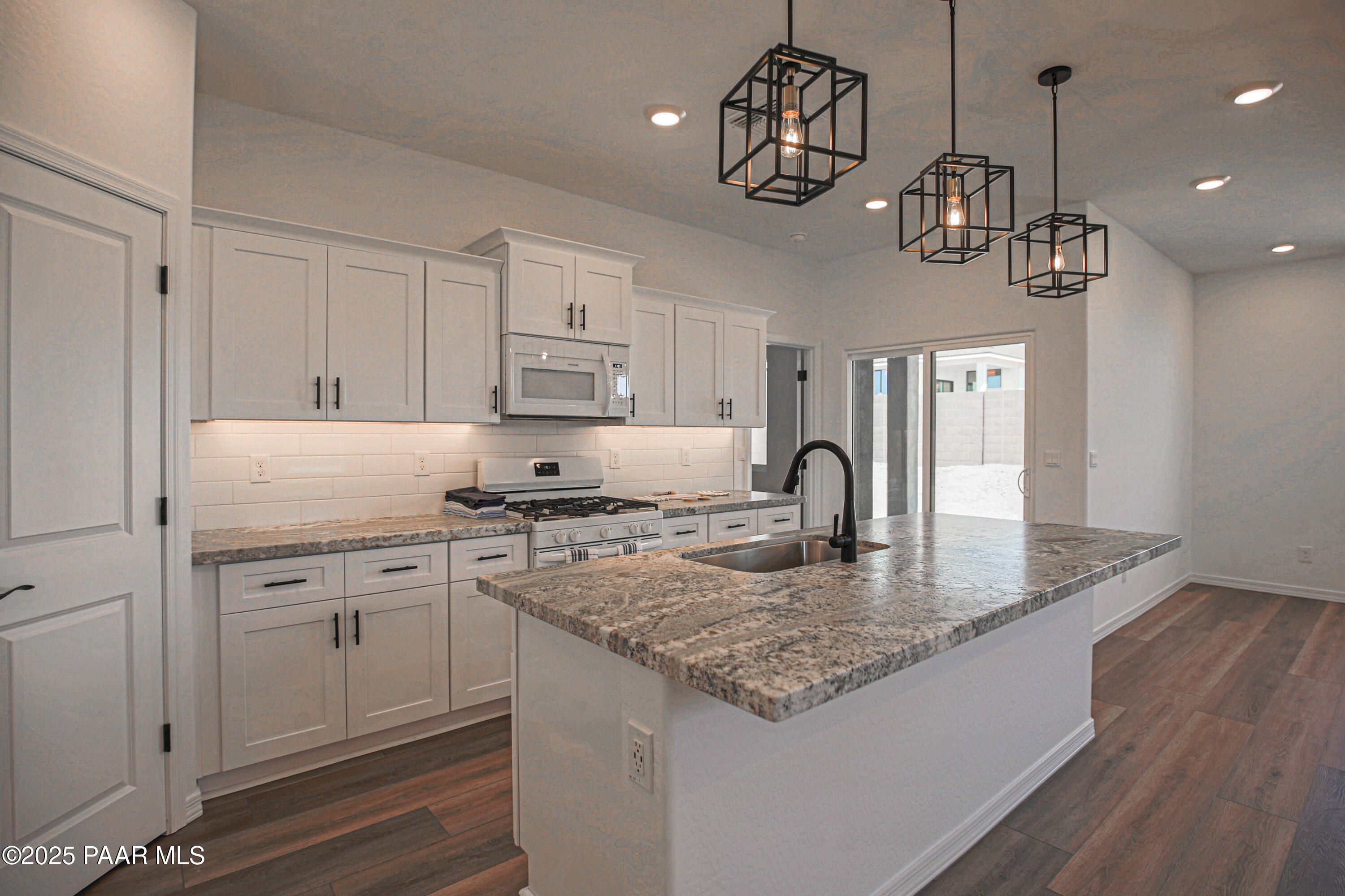 1224 Woodchute Road Prescott, AZ 86305 - Photo 5 of 43 a kitchen with kitchen island granite countertop stainless steel appliances cabinets a sink and a counter top space